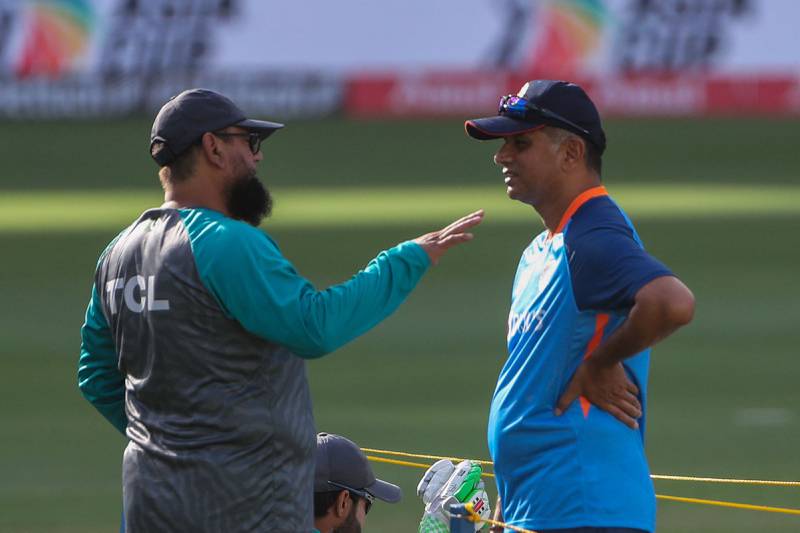 India coach Rahul Dravid, right, speaks with his Pakistani counterpart Saqlain Moshtaq before the start of the match. AFP