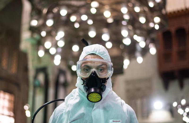 A worker wearing a protective suit poses for a photograph as he prepares to spray disinfectant in Al Fateh mosque  in Cairo. EPA