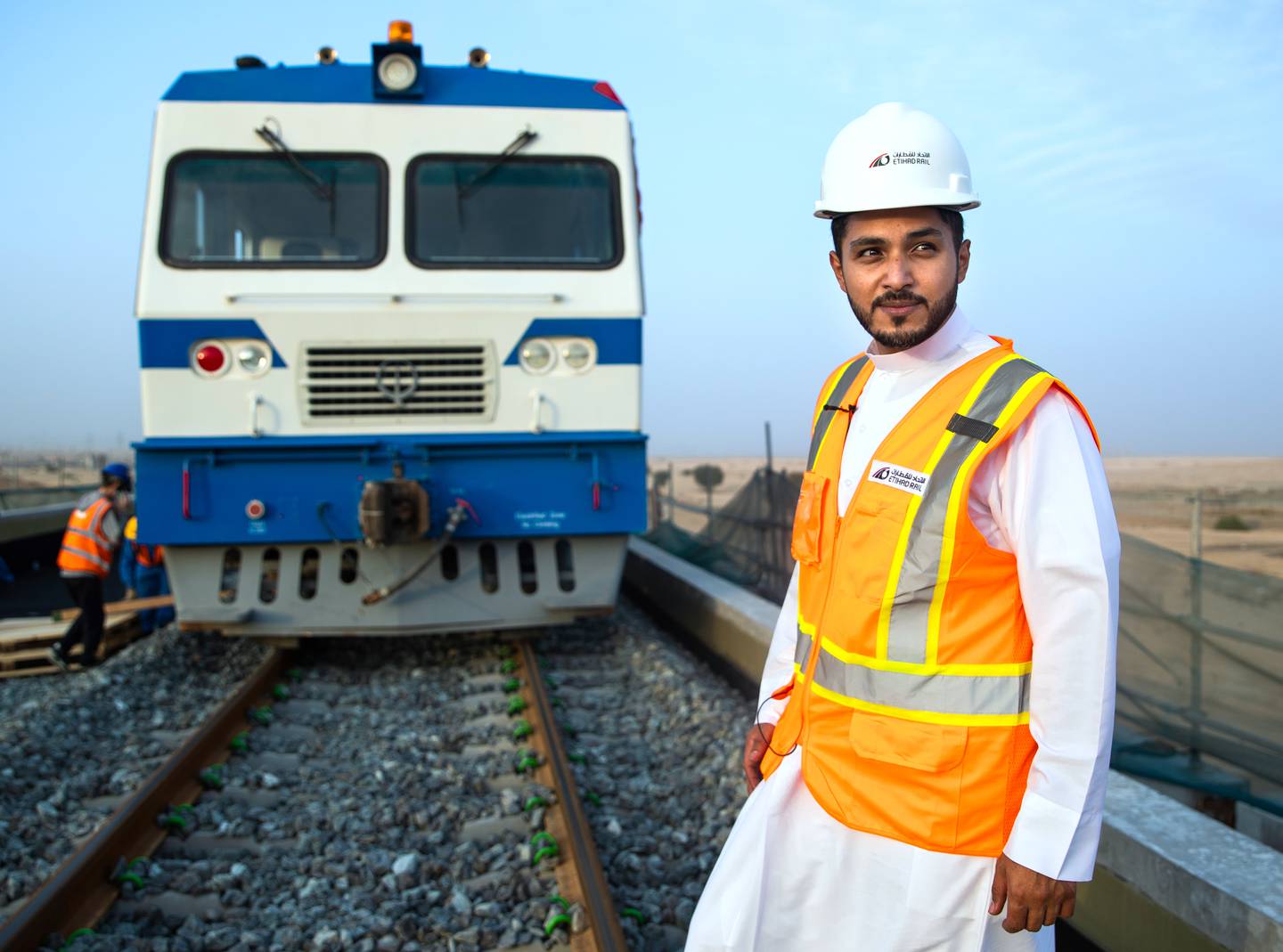 Ahmed Al Hashemi, executive director of Etihad Rail passenger sector, on the railway line. In the background is an inspection train that tests the track. Victor Besa / The National