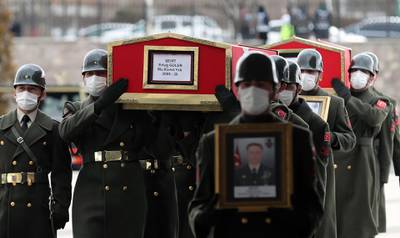 The coffin and image of Turkish Lt. Ertug Guler are carried during the funeral of three Turkish military personnel killed in action at Ankara's Ahmet Hamdi Akseki Mosque in Ankara on February 12, 2021.  The three soldiers Lt. Burak Coskun, Lt. Ertug Guler and Sgt. First Class Harun Turhan were killed during clashes with Kurdish militants in northern Iraq's Gara region as part of the Eagle Claw 2 operation by the Turkish military against the outlawed Kurdistan Workers' Party (PKK).  / AFP / Adem ALTAN
