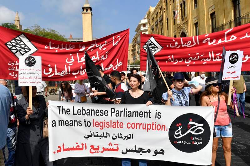 Bank customers carry placards during a protest outside the Lebanese Parliament in downtown Beirut on August 30. EPA