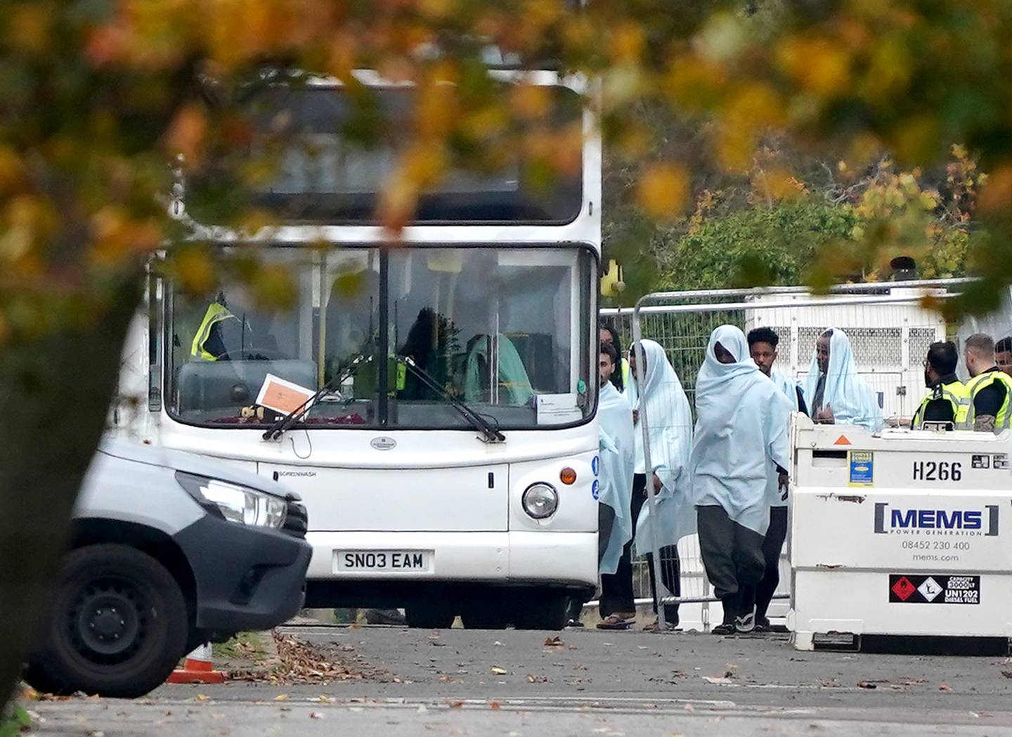 Migrants seen boarding buses at the Manston asylum processing site in Kent. PA.