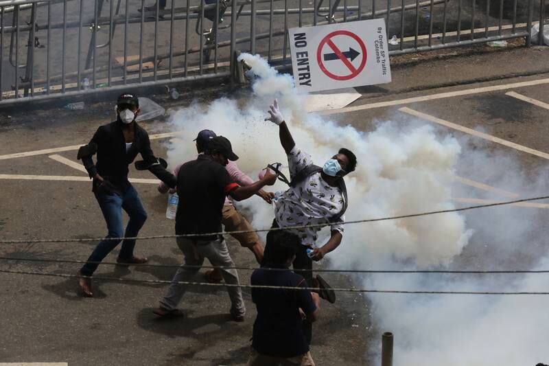 Protesters throw back tear gas canisters fired by security forces. EPA 
