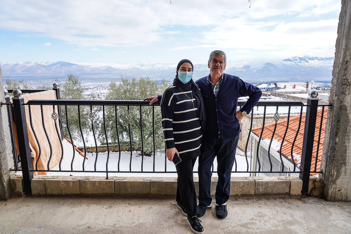 Abdallah Assaii's sister, Fatima, and her father, Ali, stand on the balcony of their home in the town of Kefraya, in Lebanon's Bekaa Valley.