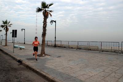 A woman runs on the empty waterfront promenade in Beirut amid a nationwide  lockdown in Lebanon. AP Photo