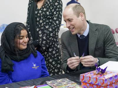 The Prince of Wales makes an origami crane with Lina Alkutbi, 15. PA