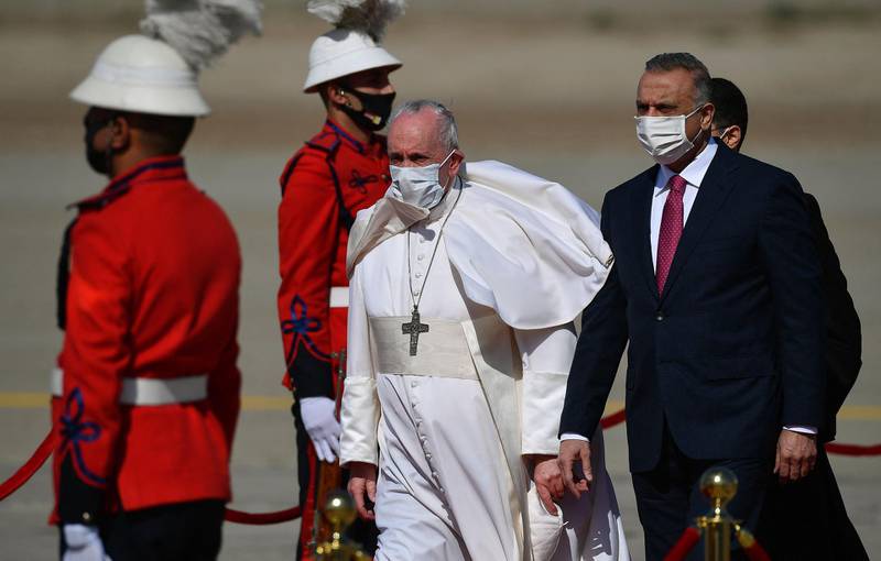 Pope Francis walks alongside Iraq's Prime Minister Mustafa Al Kadhimi upon his arrival in Baghdad. AFP