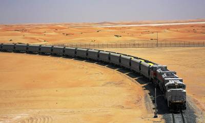 An Etihad Rail train carries sulphur through the desert along the existing track