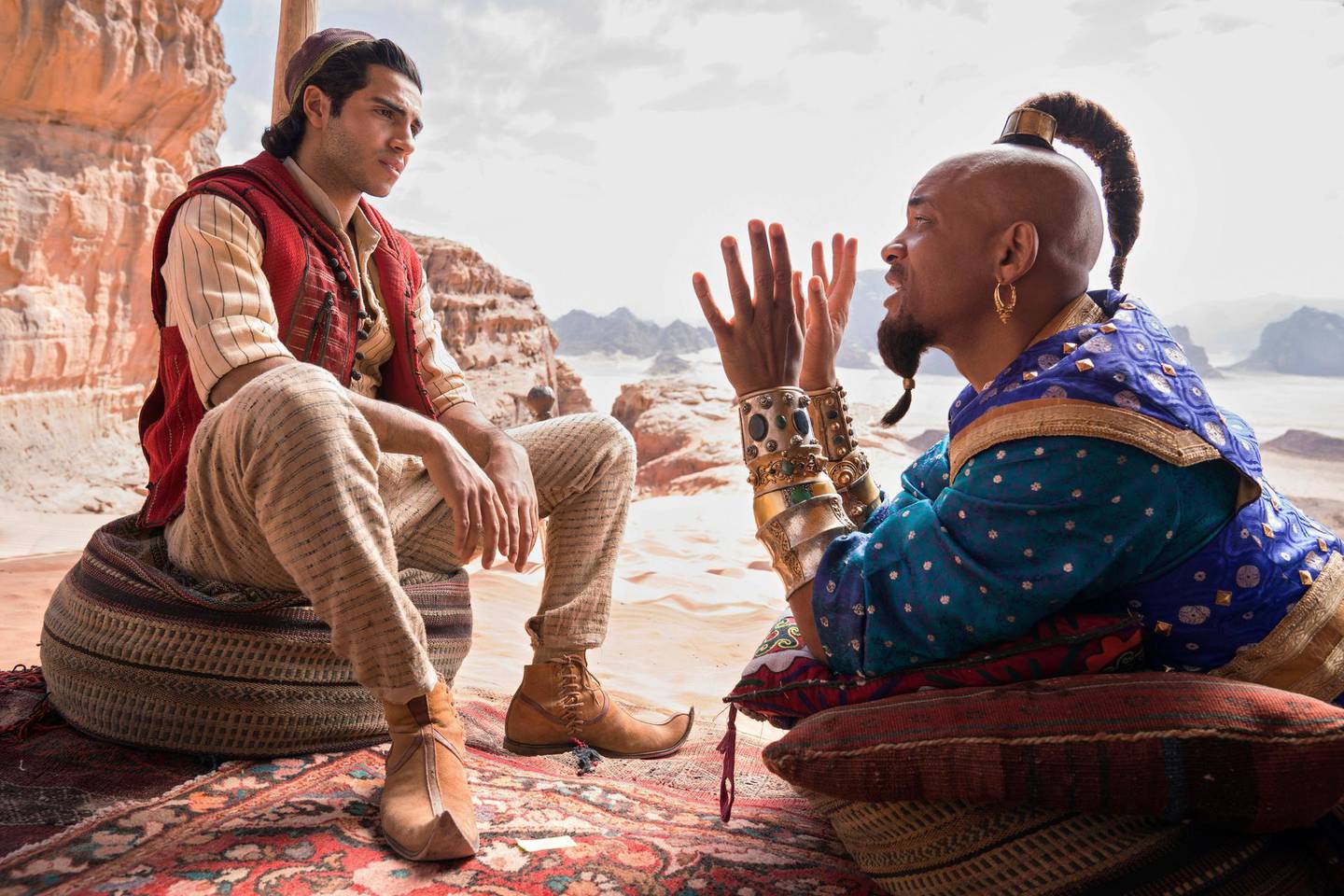 This image released by Disney shows Mena Massoud as Aladdin, left, and Will Smith as Genie in Disney's live-action adaptation of the 1992 animated classic "Aladdin." (Daniel Smith/Disney via AP)