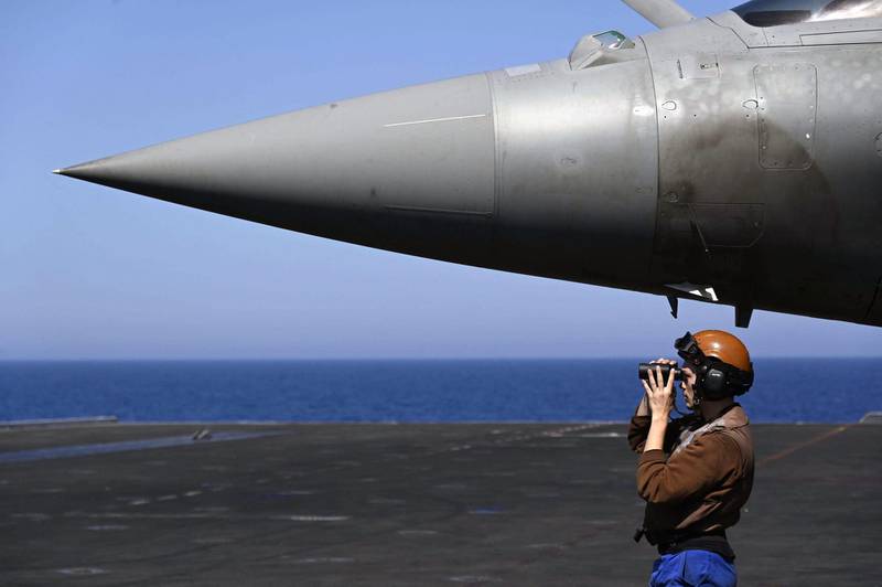 TOPSHOT - A French marine stands past the nose of a French air force Rafale jet fighter parked on  the UK Royal Navy's aircraft carrier HMS Queen Elizabeth during the Navy exercise "Gallic strike" off the coast of Toulon, south-eastern France on June 3, 2021. This unprecedented joint maneuver called "Gallic Strike", which has mobilized since two days 14 warships and 56 combat aircraft off the coast of Toulon, aims in particular to train to conduct strikes from the sea, and to operate jointly the tricolor Rafale Marine fighter planes, catapulted, and the British F-35s which take off vertically or using a springboard.  / AFP / Christophe SIMON
