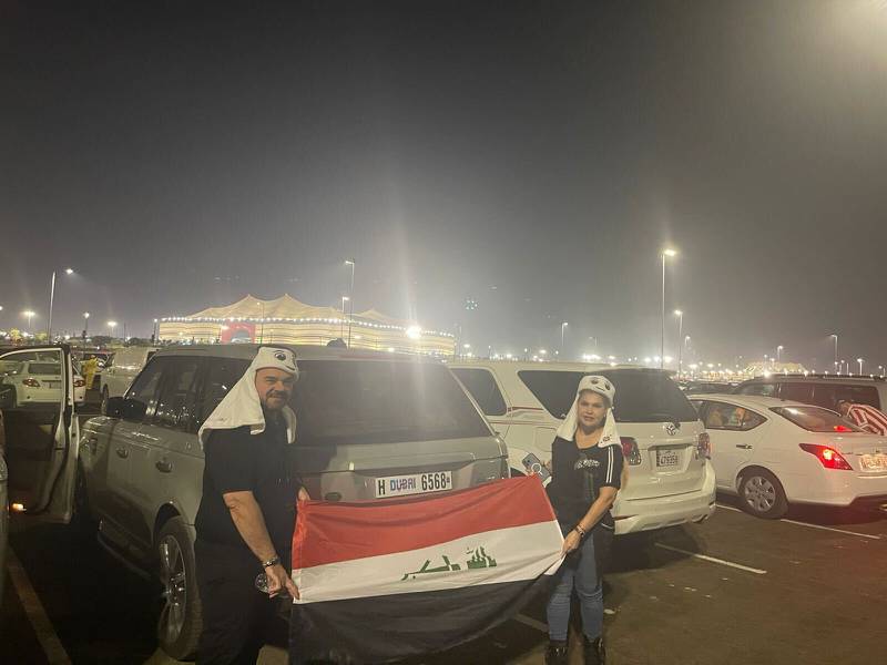 Dr Khayat and his wife proudly show their Iraqi flag outside Al Bayt Stadium