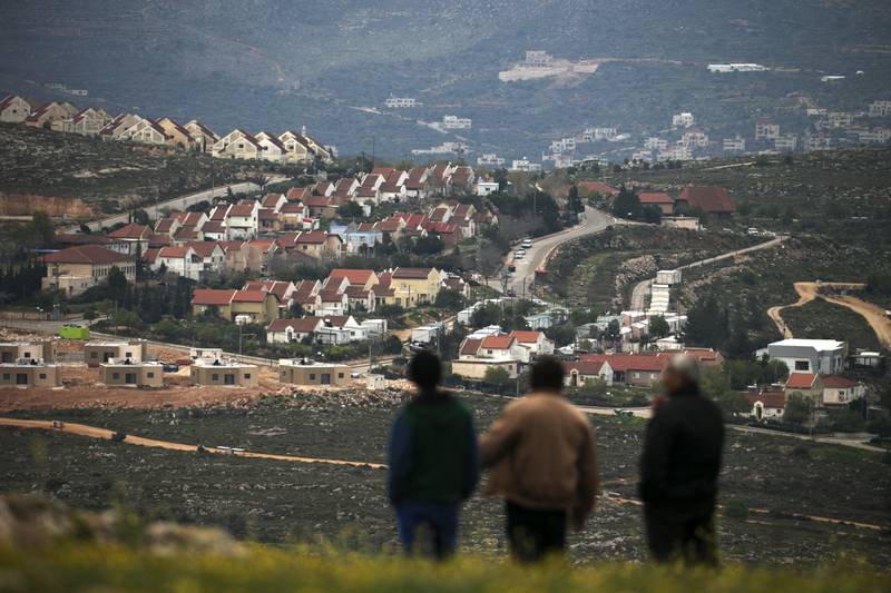 People look at the Jewish settlement of Shvut Rachel during a tour organised by the Palestinian authorities for ambassadors based in Tel Aviv and consuls based in Jerusalem to show the development of Israeli settlements in the occupied West Bank, on March 16, 2017.