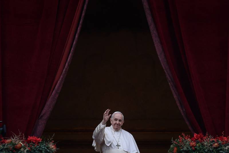 Pope Francis waves to the gathered faithful following his Christmas blessing in St Peter's Square at the Vatican. AFP