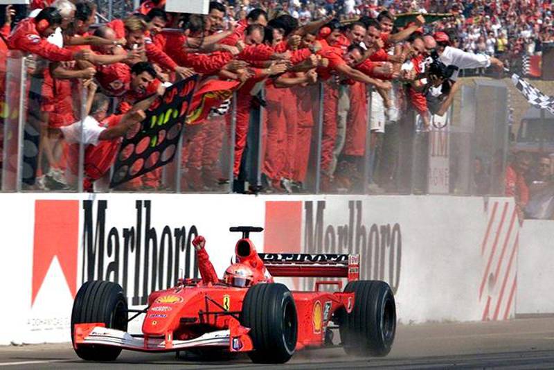 epa03420657 (FILE) German Formula One Ferrari driver Michael Schumacher celebrates with a raised fist driving past his mechanics hanging over the walls of the box on 19 August 2001 after winning the Hungarian Grand Prix to clinch his fourth Formula One world championship. On 04 October 2012 Schumacher announced that he will retire at the end of the season. This being the second time the 7-season world champion retires. Schumacher's seat at Mercedes will be taken by McLaren's Lewis Hamilton in 2013.  EPA/ATTILA KISBENEDEK