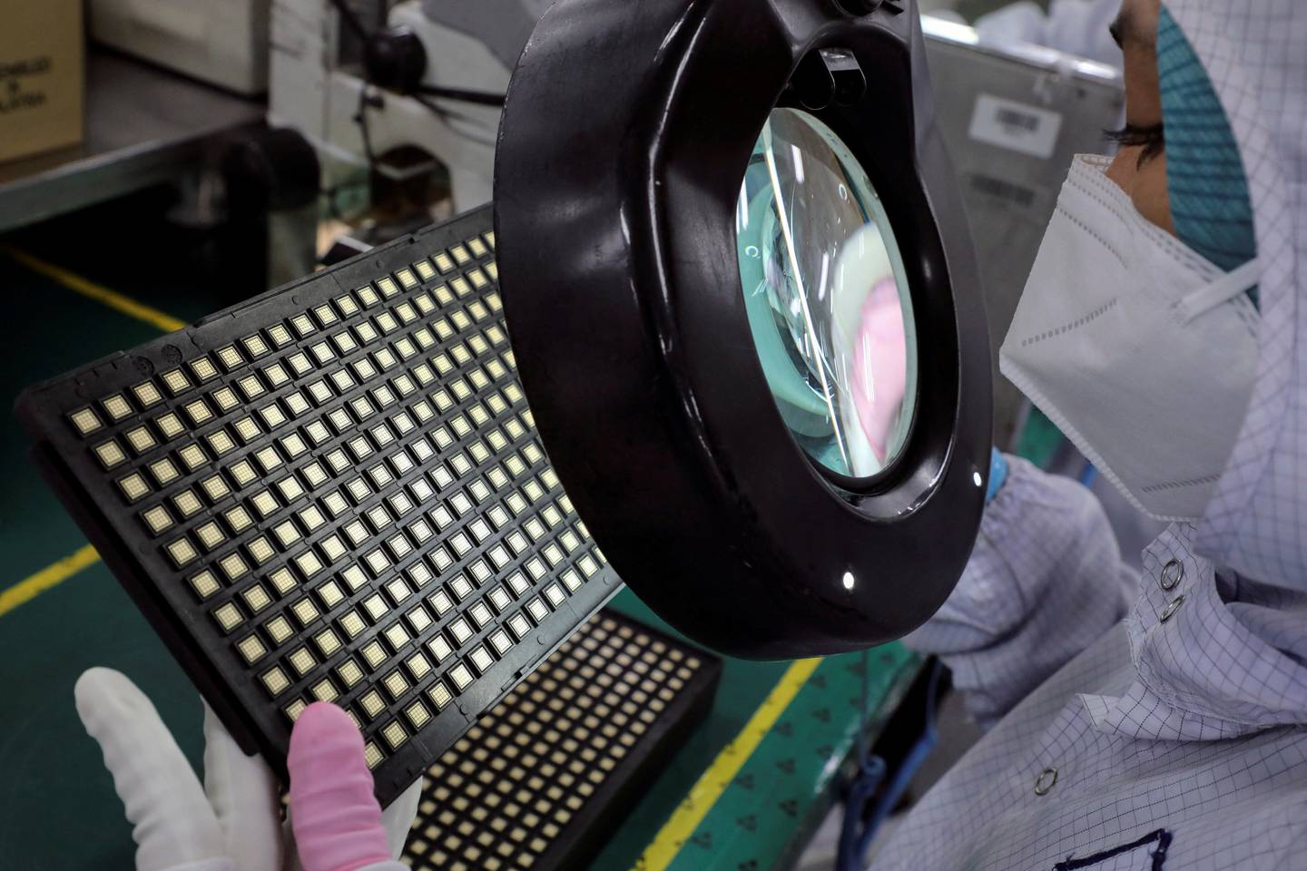A worker inspects semiconductor chips at the Unisem Berhad plant in Malaysia. Reuters 