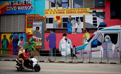 People walk past a mural depicting the coronavirus pandemic in Bangaluru, India, that was created by the Aravani art project to create awareness about the health crisis.  EPA