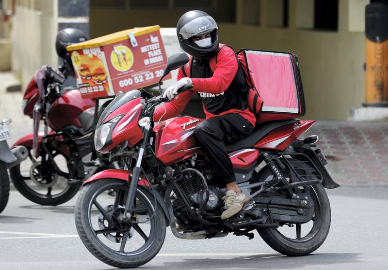 Dubai, United Arab Emirates - Reporter: N/A: A Zomato driver delivers food with a facemask on due to the corona outbreak. Monday, April 13th, 2020. Dubai. Chris Whiteoak / The National