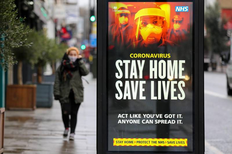 LONDON, UNITED KINGDOM - 2021/01/12: A woman walks past the Government's 'Stay Home, Save Lives' Covid-19 publicity campaign poster in London, as the number of cases of the mutated variant of the SARS-Cov-2 virus continues to spread around the country. (Photo by Dinendra Haria/SOPA Images/LightRocket via Getty Images)