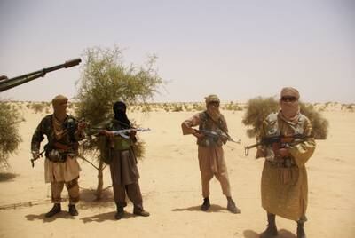 Members of an extremist group stand guard during a hostage handover in the desert outside Timbuktu, Mali. AP