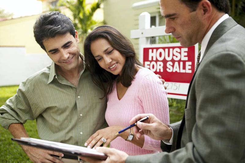 Couple and realtor signing papers for new house