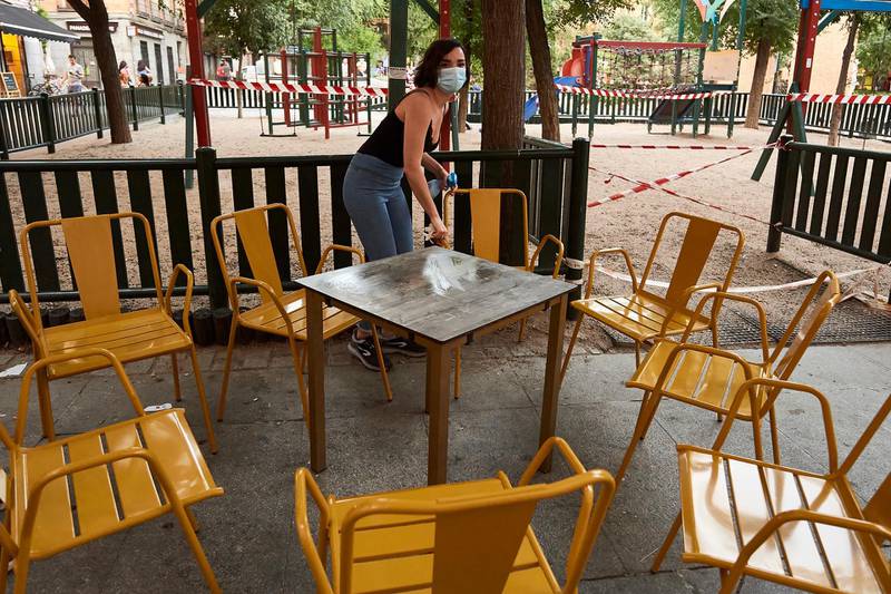 An employee cleans a table before offering it to customers at the Gato terrace in Madrid, Spain. All regions of Spain have now entered either Phase One or Phase Two of the transition from its coronavirus lockdown. Getty Images