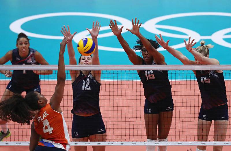 Celeste Plak of Netherlands spikes the ball against Kelly Murphy and Foluke Akinradewo of United States during the women’s bronze medal match between Netherlands and the United States on Day 15 of the Rio 2016 Olympic Games at the Maracanazinho on August 20, 2016 in Rio de Janeiro, Brazil. Buda Mendes / Getty Images