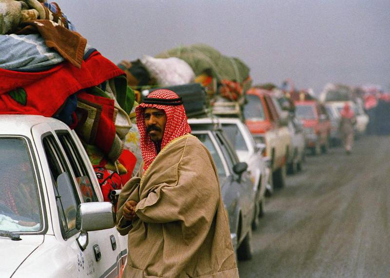 A Kuwaiti refugee stands beside his car outside Kuwait City after Iraq invaded 30 years ago. Scott Applewhite / AP