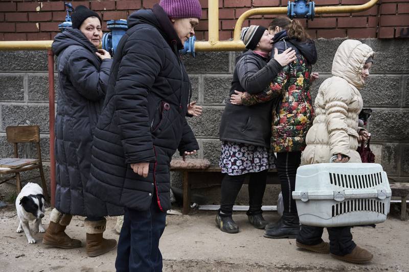 Nastya carries her cat as her mother Anna says goodbye to neighbours with whom they lived for months in a basement during Russian attacks in Soledar, a city in the Donetsk enclave of Ukraine. AP