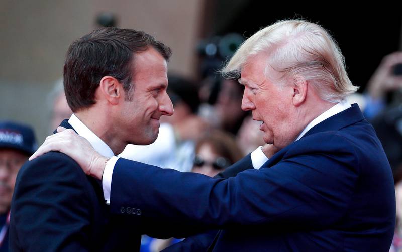 TOPSHOT - US President Donald Trump (R) talks with French President Emmanuel Macron during a French-US ceremony at the Normandy American Cemetery and Memorial in Colleville-sur-Mer, Normandy, northwestern France, on June 6, 2019, as part of D-Day commemorations marking the 75th anniversary of the World War II Allied landings in Normandy.  / AFP / POOL / Ian LANGSDON
