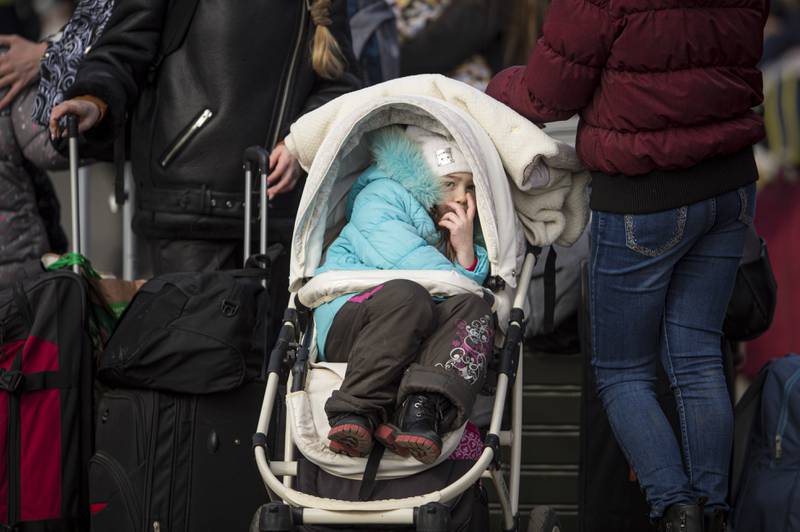 A child sits in a pushchair after fleeing Ukraine at the Romanian border in Siret. AP