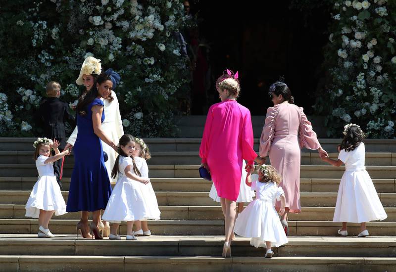 Kate, the Duchess of Cambridge, foreground left and Jessica Mulroney, in blue arrive with the bridesmaids for the wedding ceremony of Prince Harry and Meghan Markle. Pictured far right in light pink is Benita Litt, whose daughters count Meghan, now the Duchess of Sussex, as their godmother. AFP