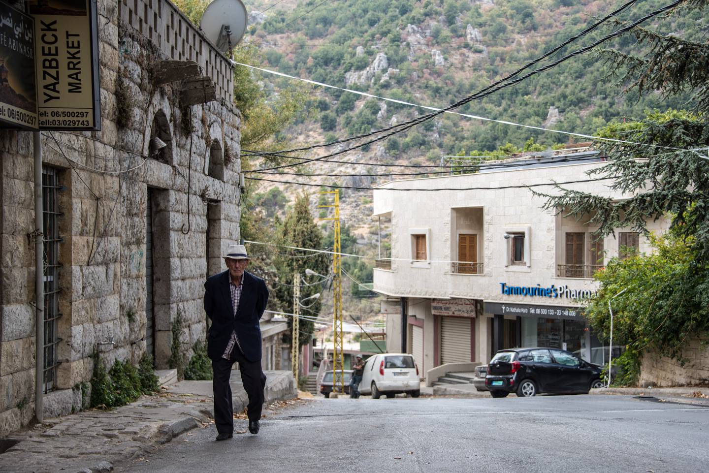 An old man walks past the pharmacy and on up Tannourine high street. Picture: Elizabeth Fitt 