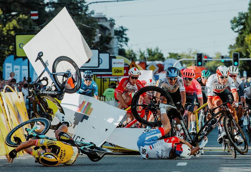 (FILES) In this file photo taken on August 5, 2020 Dutch cyclist Fabio Jakobsen's bicycle (behind,L) flies through the air as he collides with compatriot Dylan Groenewegen (on the ground ,L) during the opening stage of the Tour of Poland race in Katowice , southern Poland. A few days before the start of the Tour de France, after the fall of Remco Evenepoel during the Tour of Lombardy and the one of Fabio Jakobsen during the Tour of Poland, the the cyclist struggle with this series of accidents which marked the resumption of the races. / AFP / Forum / Szymon Gruchalski
