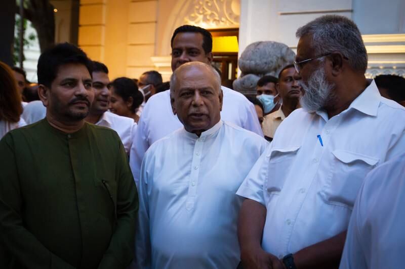 Dinesh Gunawardena, centre, leader of the House of Parliament, arrives at Gangaramaya Temple in Colombo. Getty