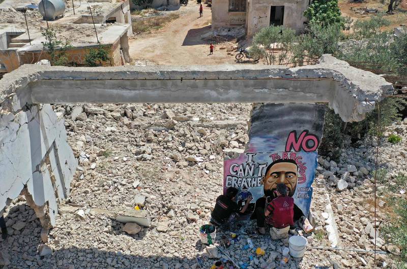 An aerial view shows Syrian artists Aziz Asmar and Anis Hamdoun painting a mural depicting George Floyd in Syria's northwestern Idlib province.  AFP