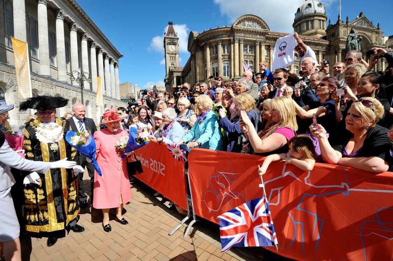 The queen receives flowers from members of the public in Victoria Square, Birmingham during her diamond jubilee visit in July 2012.