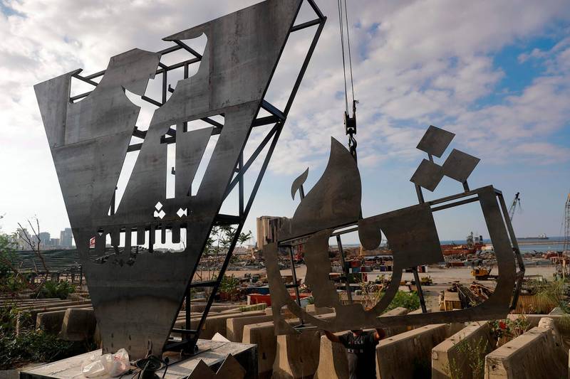 Lebanese activists erect a metalic monument with 'October 17' written on it in Arabic in front of the devastated port of the capital Beirut where a massive explosion took place more than two months ago. AFP