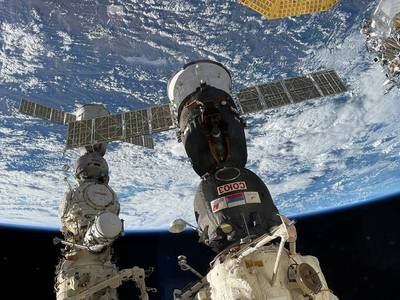 The Soyuz spacecraft, left, took the three men to a parachute-assisted landing in Kazakhstan. Reuters