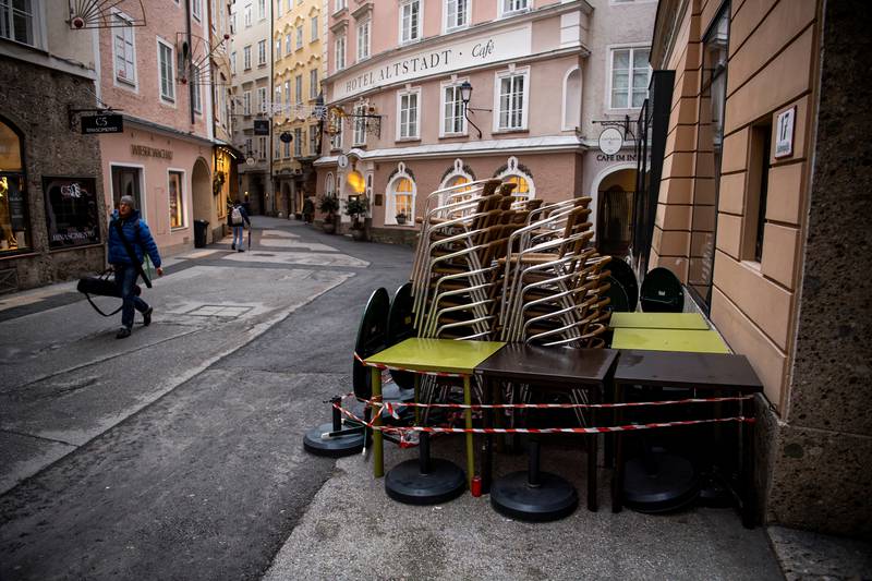 Tables and chairs at a cafe in the Austrian city of Salzburg, on the border with Germany, are stacked on Monday as the coronavirus lockdown begins. Reuters