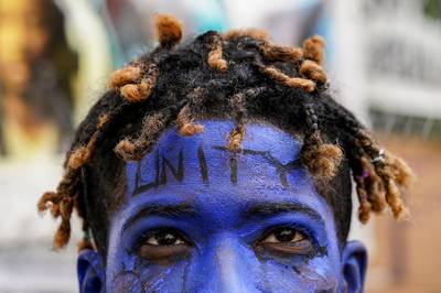 A demonstrator going by the name Azul Azul walks around with a painted face outside the White House in Washington. AP Photo