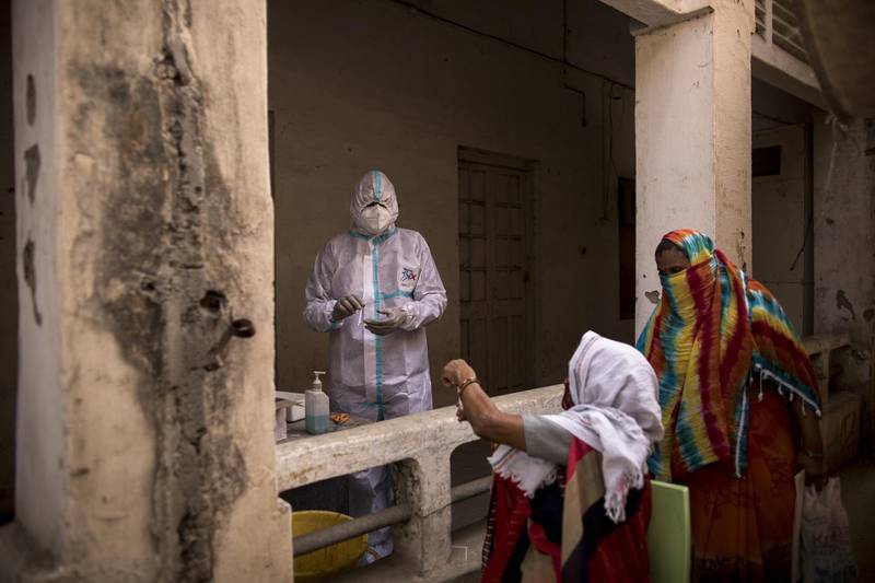 A health worker prepares to swab a woman at a Covid-19 testing site set up in the employment exchange office in the northern Indian city of Agra. Anindito Mukherjee/Bloomberg