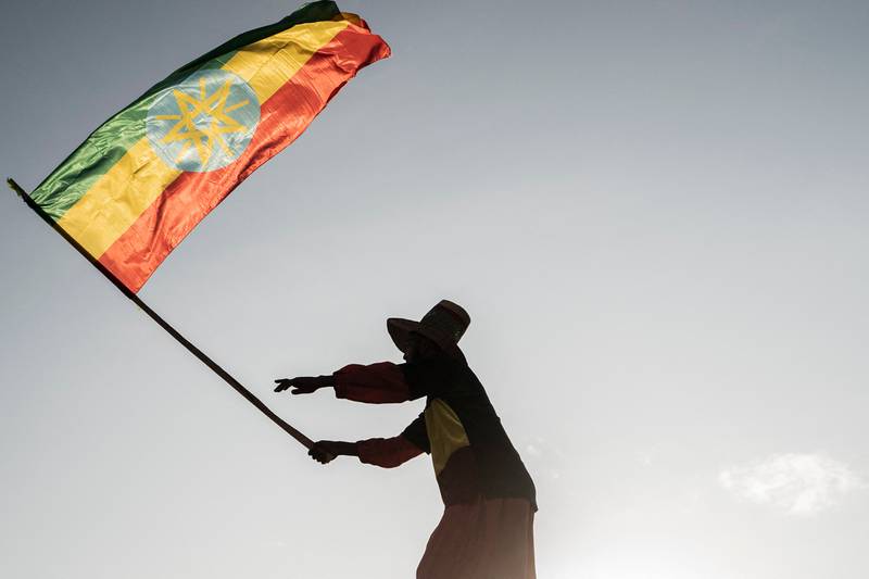 A man waves an Ethiopian flag as he join others gathering in Addis Ababa, Ethiopia during a demonstration in support of Ethiopia armed forces. AFP