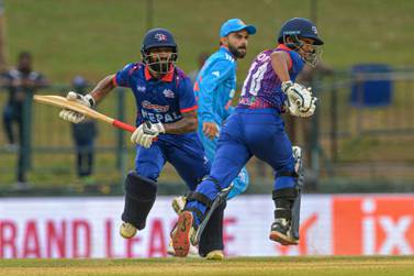 Nepal's Dipendra Singh Airee (L) and Sompal Kami (R) run between the wickets as India's Virat Kohli (C) watches during the Asia Cup 2023 one-day international (ODI) cricket match between India and Nepal at the Pallekele International Cricket Stadium in Kandy on September 4, 2023.  (Photo by Ishara S.  KODIKARA  /  AFP)