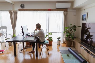 A woman using a computer in the living room of her home