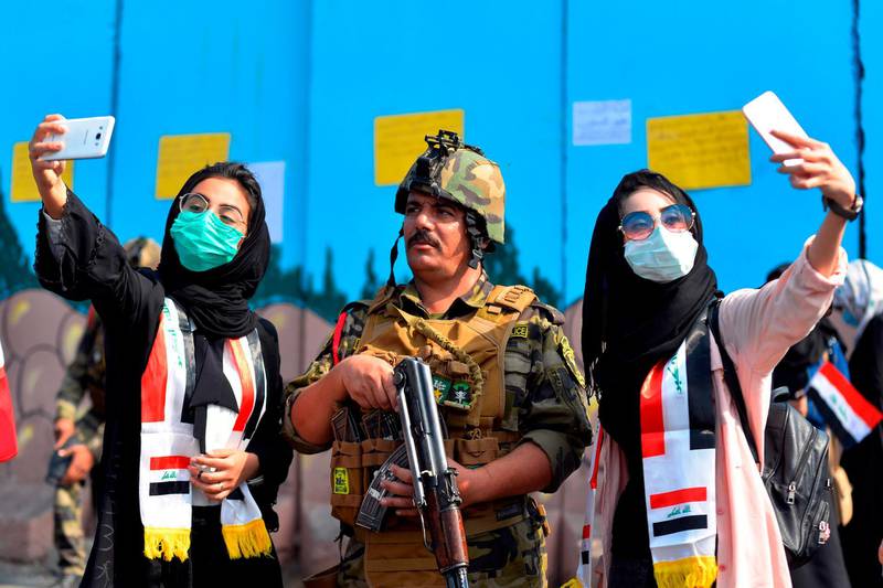 Students pose for selfies with a member of the security forces during ongoing anti-government protests in Diwaniyah. AFP