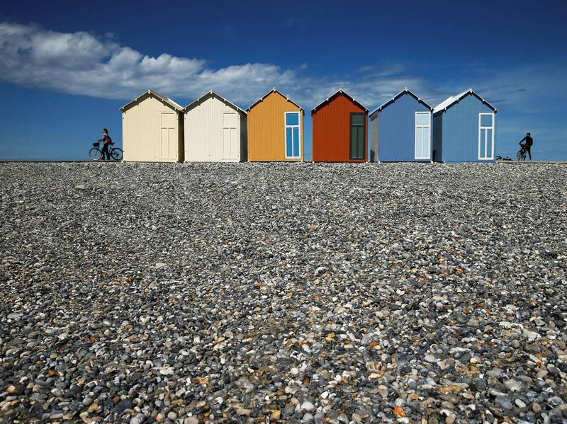 Cyclists are seen near beach huts on a pebble beach, after France reopened its beaches to the public as it softens its strict lockdown rules during the outbreak of the coronavirus disease (COVID-19), in Cayeux-sur-Mer, France. REUTERS
