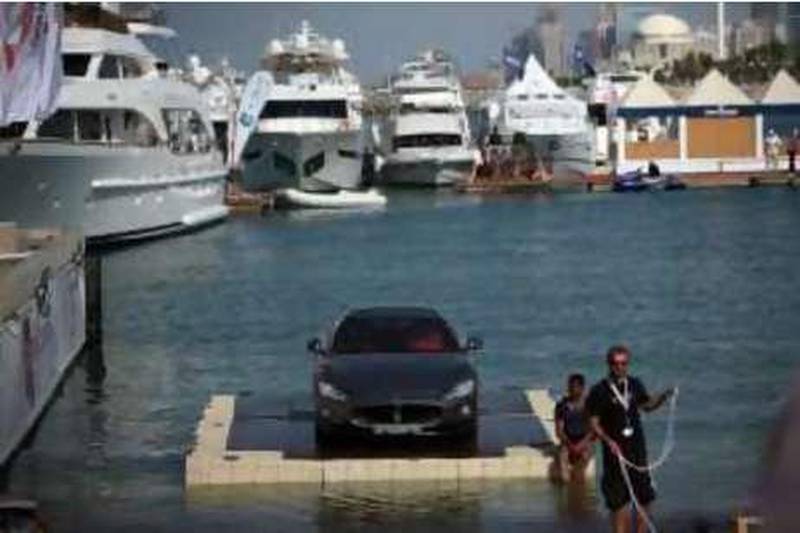 United Arab Emirates - Abu Dhabi - Nov. 25, 2008:
Workers try to bring a Maserati up a ramp to be displayed next to luxury boats at the Emirates Boat Show International (cq-al) at the Abu Dhabi International Sports Marina in Abu Dhabi on Tuesday, Nov. 25, 2008. Amy Leang/The National  

 *** Local Caption ***  al_112508_boatshow_08.JPG