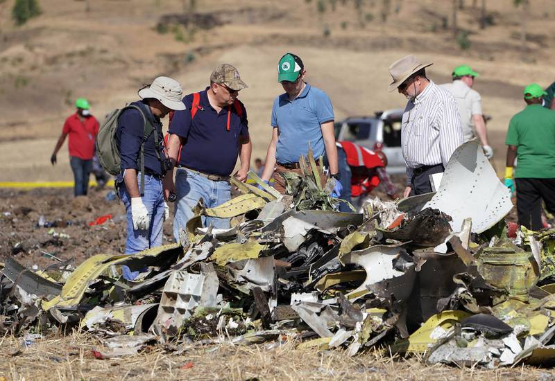 Investigators with the US National Transportation and Safety Board (NTSB) look over debris at the crash site. Getty Images