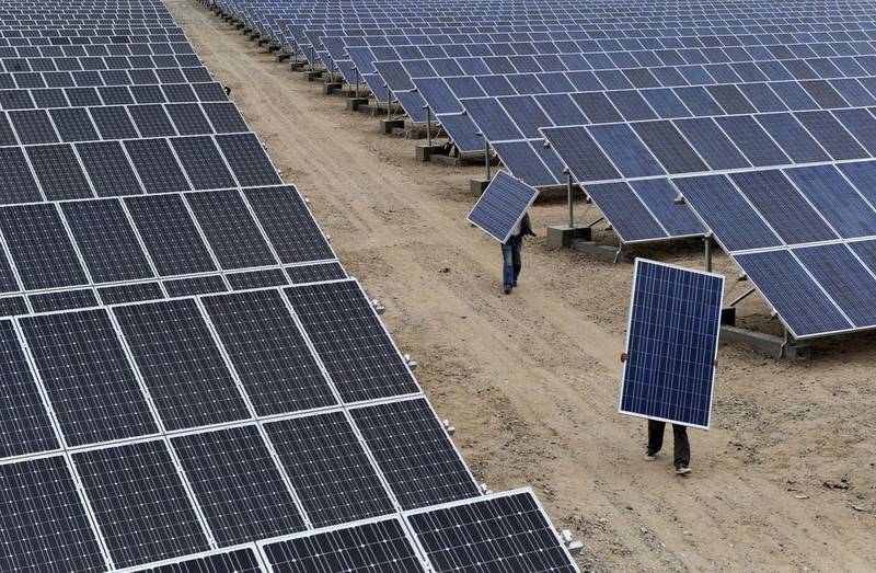 Kuwait is joining the global league of solar power producers, such as China, with its new plant. Here, employees carry panels at a plant in Aksu, China  Courtesy Reuters