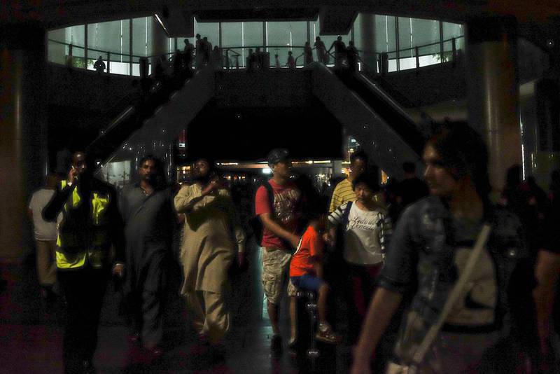 Dubai Mall shoppers walk in the dark.  AFP